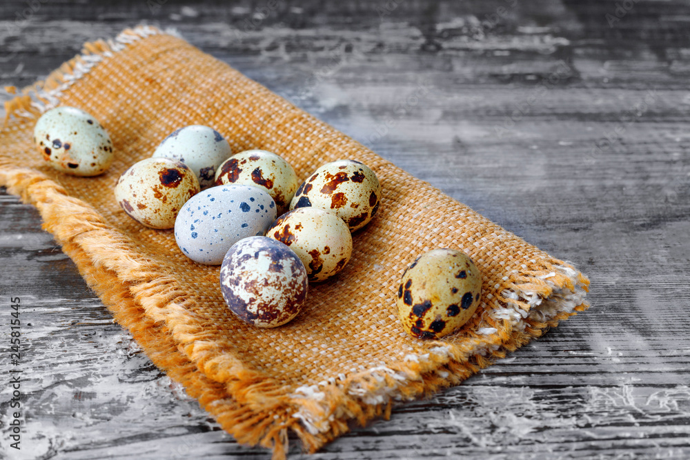 Fresh quail eggs on burlap on background of wooden floor Fresh quail eggs on burlap on background of wooden floor