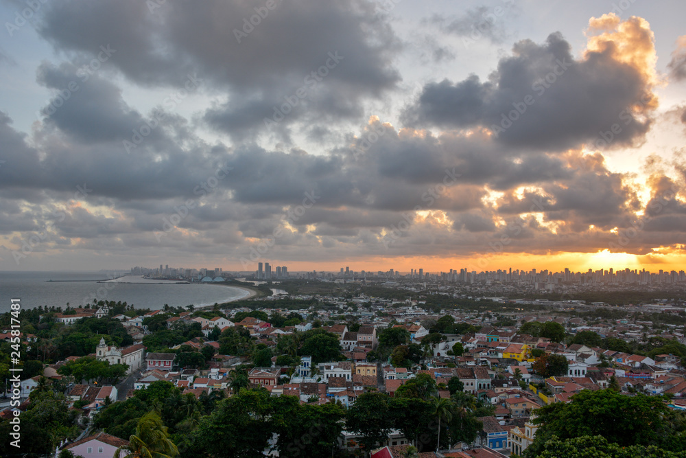 Aerial view of the historic city of Olinda in Pernambuco, Brazil at sunset contrasting with the contemporary skyscrapers of Recife in the far background