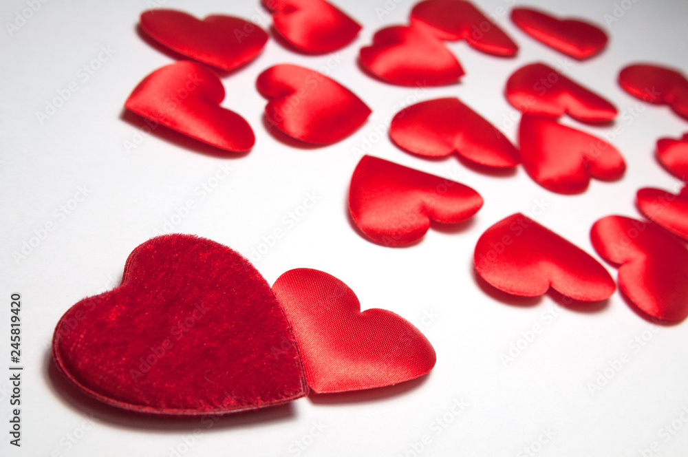 Two red hearts are near and many small blurred hearts. The concept of two loving people who have found each other among hundreds of other lonely hearts. Decorative hearts for Valentine's day. Two red hearts are near and many small blurred hearts. The concept of two loving people who have found each other among hundreds of other lonely hearts. Decorative hearts for Valentine's day.