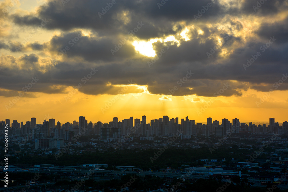 Fototapeta premium Aerial view of the historic city of Olinda in Pernambuco, Brazil at sunset contrasting with the contemporary skyscrapers of Recife in the far background