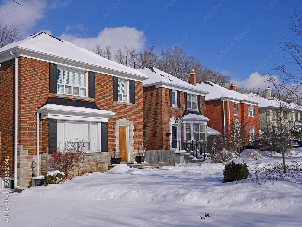 middle class residential street with brick houses in winter. middle class residential street with brick houses in winter.