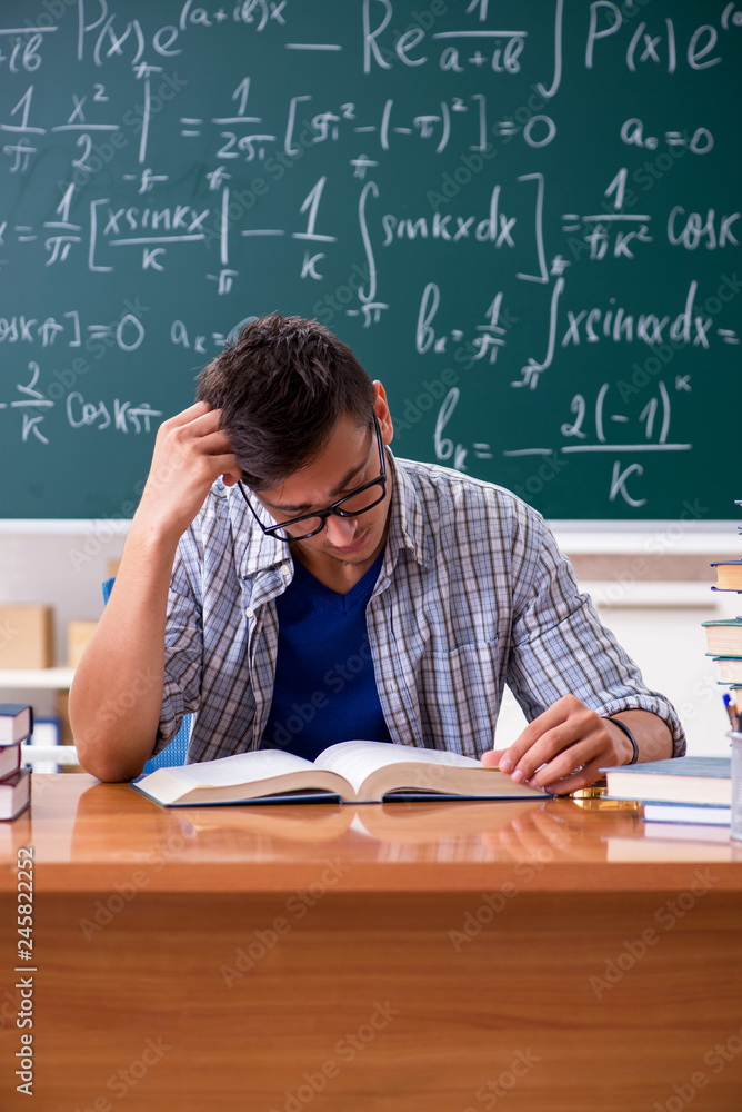 Young male student studying math at school Young male student studying math at school