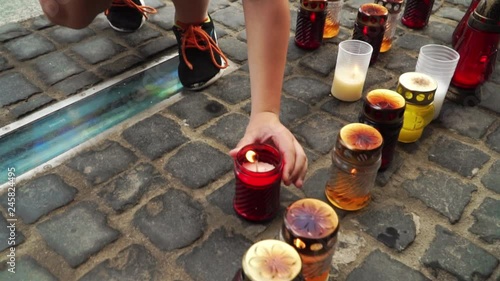 a child holds a burning candle at the monument