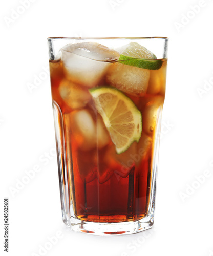 Glass of cocktail with cola, ice and cut lime on white background