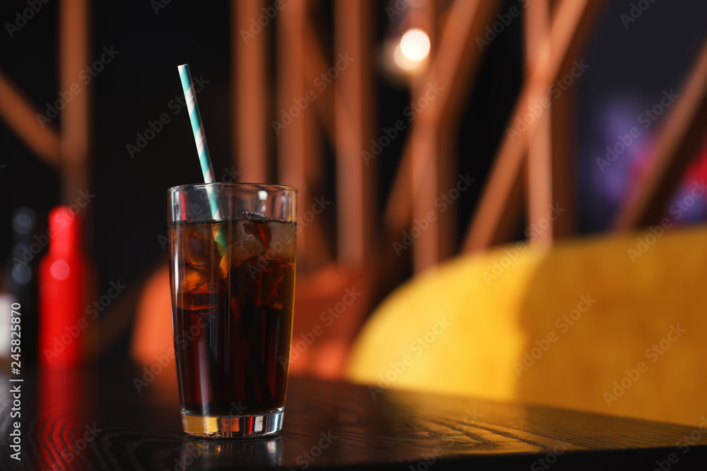Fototapeta Glass of refreshing cola with ice on table indoors. Space for text