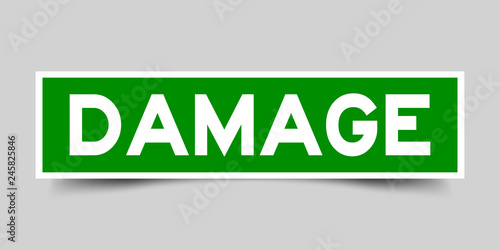 Square green color sticker with word damage on gray background