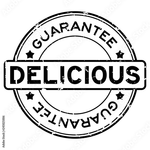 Grunge black delicious guarantee word round rubber seal stamp on white background