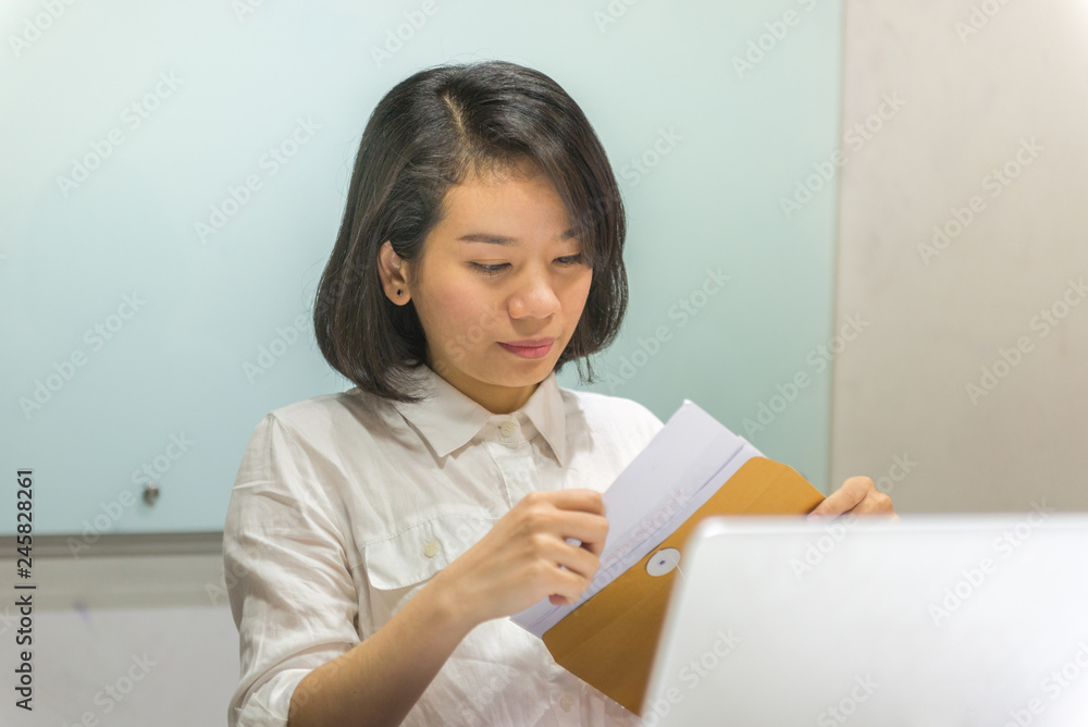 Young businesswoman checking financial report in the workplace Young businesswoman checking financial report in the workplace