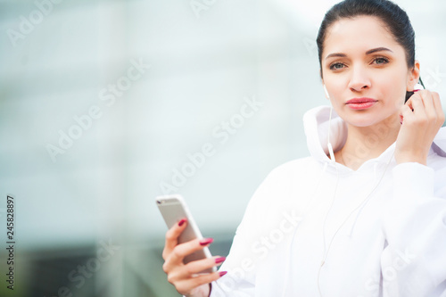 Fitness. Woman listening music on phone while exercising Outdoors - Sport and healthy lifestyle concept