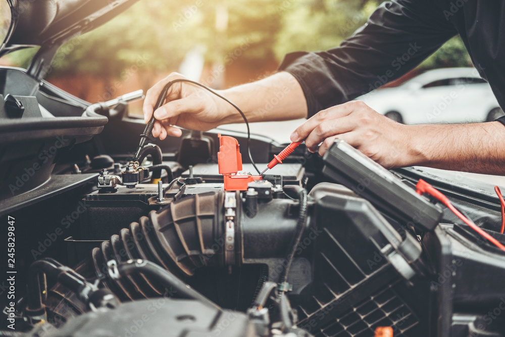 Auto mechanic working in garage Technician Hands of car mechanic working in auto repair Service and Maintenance car battery check. Auto mechanic working in garage Technician Hands of car mechanic working in auto repair Service and Maintenance car battery check.