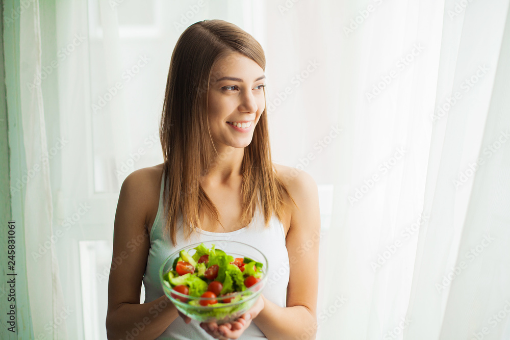 Healthy salad. Young beautiful woman eating salad