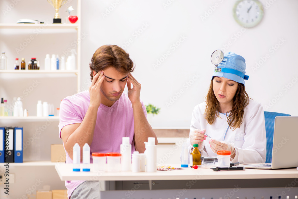 Obraz premium Young handsome man visiting young female doctor otolaryngologist