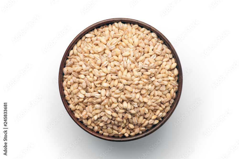 Peeled barley in a wooden bowl, isolated on white background. Top view. Peeled barley in a wooden bowl, isolated on white background. Top view.