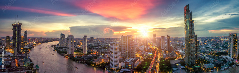 Naklejka premium Aerial view of Bangkok buildings, Bangkok city downtown with sunset sky, Transaction beautiful road top view at night traffic