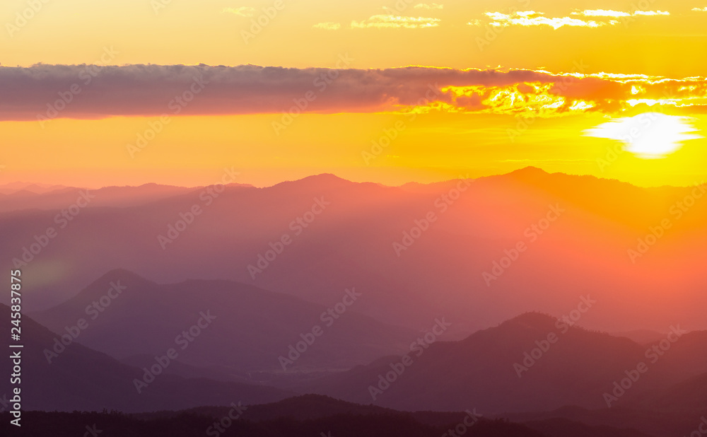Hazy mountain range with dramatic sunset sky