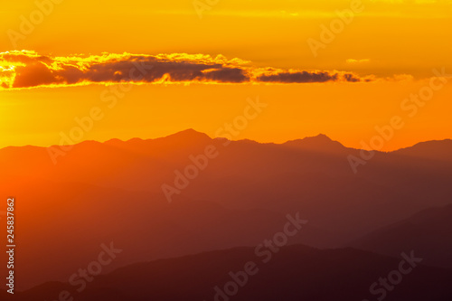 Hazy mountain range with dramatic sunset sky