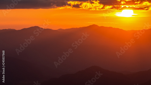 Hazy mountain range with dramatic sunset sky