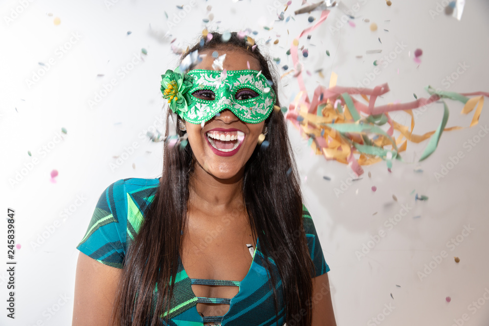 people, holidays, emotion and carnival concept - happy young woman with mask and confetti at carnaval party. Carnaval concept