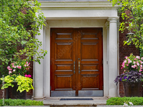 Photography elegant double wooden front door and portico entrance surrounded by flowers of u