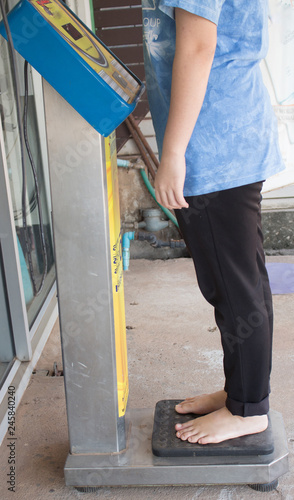 Overweight woman standing on weighing scale
