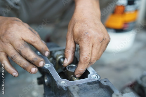 Hand working on car's engine