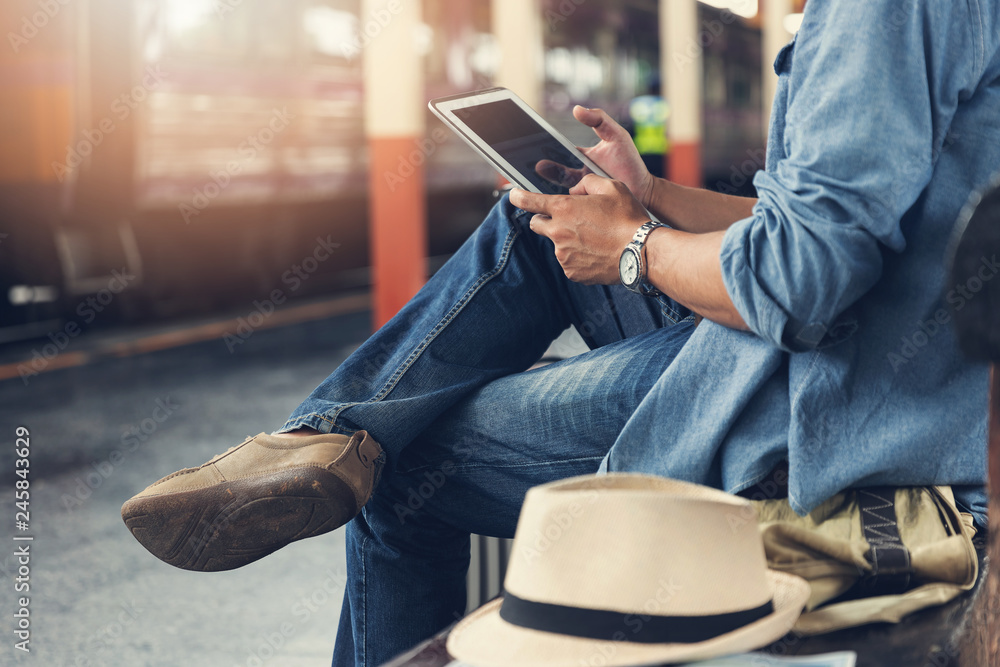 Asian traveler man use tablet to buy train ticket online at train station Asian traveler man use tablet to buy train ticket online at train station