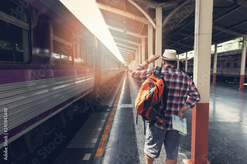 Asian traveler man with belongings waiting for travel by train