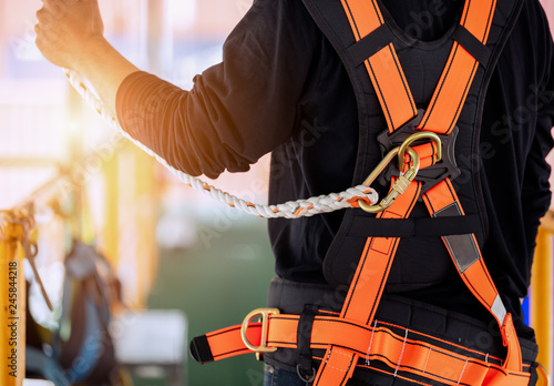 Construction worker wearing safety harness and safety line working high place at industrial. photo