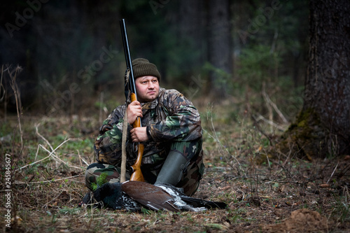 hunter with prey in the forest after hunting rests