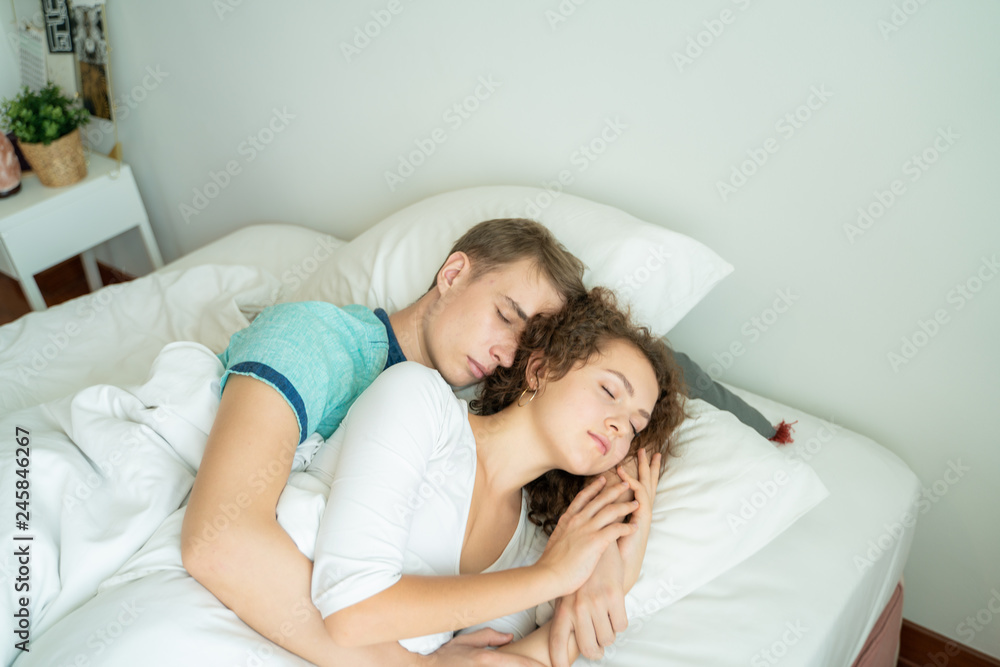 Beautiful young man and women love couple hugging on bed Beautiful young man and women love couple hugging on bed