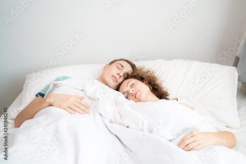 Beautiful young man and women love couple hugging on bed