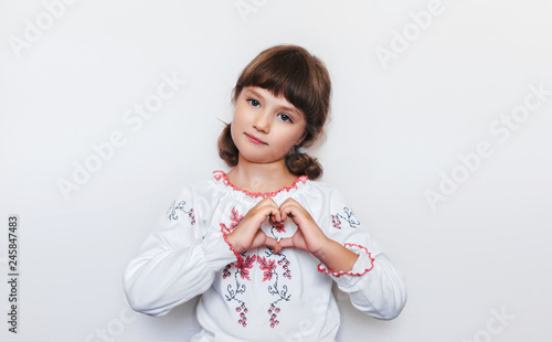 Little Ukrainian girl makes a heart shape with her hands. Love to motherland. Patriotic feelings. Native country.