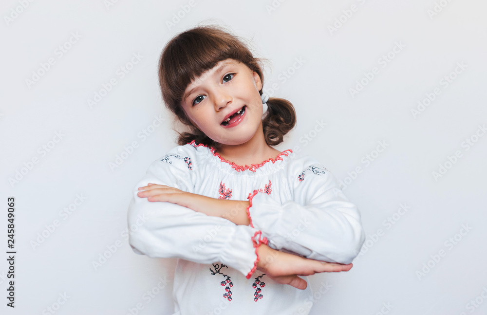 Beautiful little Ukrainian girl happily smiling. First-grade student with fall out baby teeth. Beautiful little Ukrainian girl happily smiling. First-grade student with fall out baby teeth.