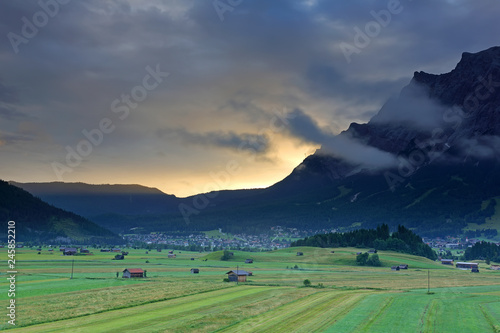 Summer of very large farm with the village and Mt. Zugspitze on the sunrise with fog   Ehrwald  Wetterstein mountain range at Biberwier  Tyrol  Austria 