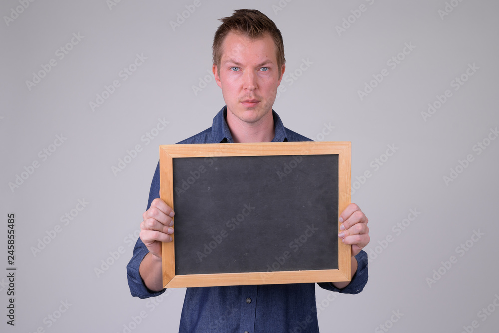 Portrait of young handsome businessman holding blackboard Portrait of young handsome businessman holding blackboard