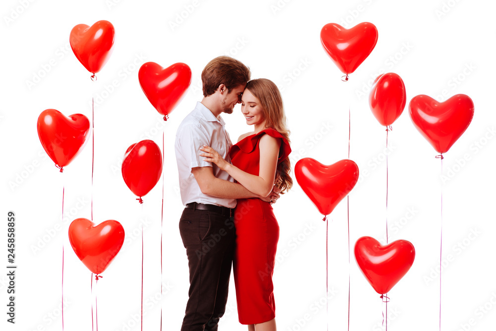 Kissing couple posing on white background with balloons heart. Valentine's day. Kissing couple posing on white background with balloons heart. Valentine's day.