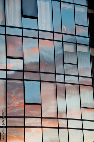 Reflection of pastel Sun set on window glass of modern corporate office building