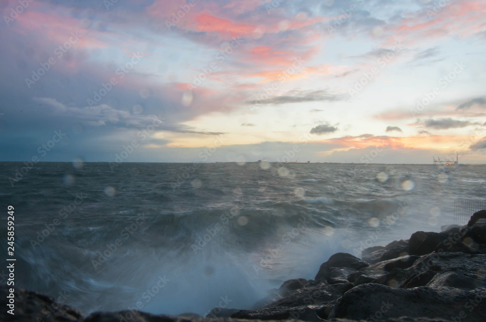 Dramatic splashing ocean wave in the evening with twilight sky in Winter at breakwater at St Kilda pier in Melbourne Australia Dramatic splashing ocean wave in the evening with twilight sky in Winter at breakwater at St Kilda pier in Melbourne Australia