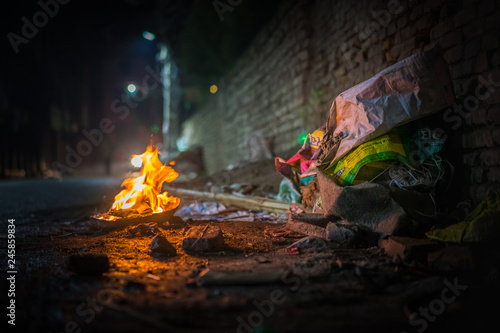 Garbage fire at night with burning rubbish on a filthy street