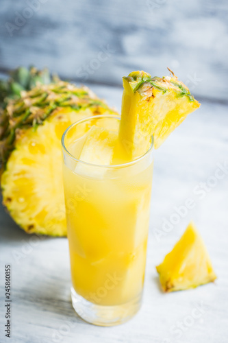 Fresh pineapple beverage on rustic background. Selective focus. Shallow depth of field.
