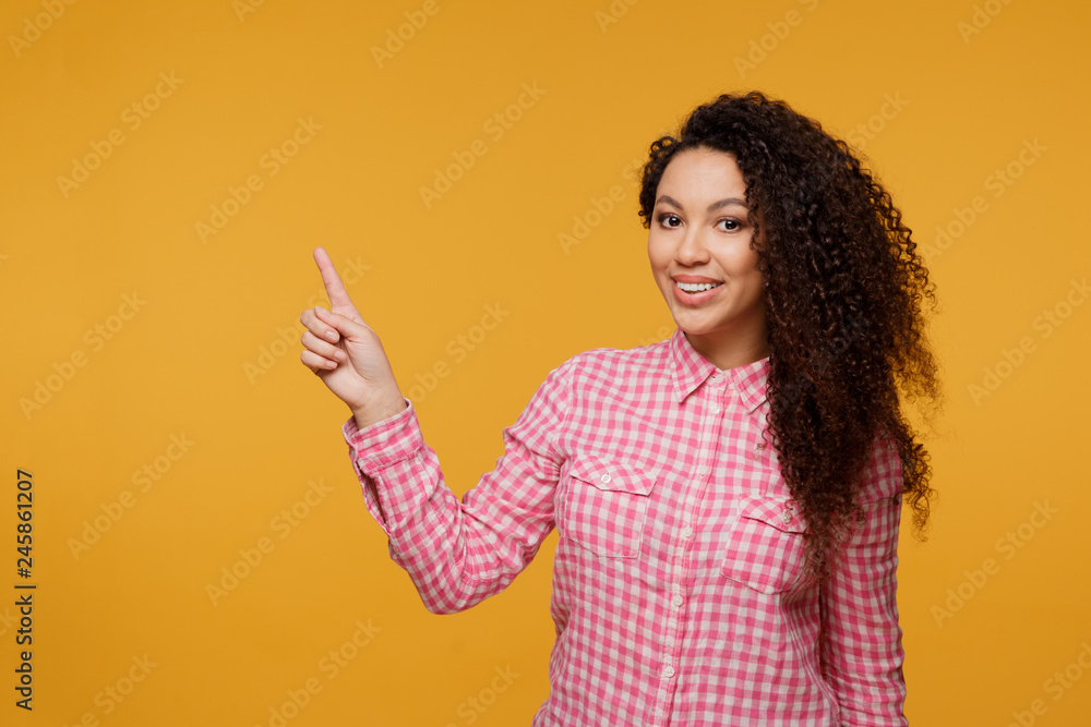 Portrait of a happy smiling young girl standing isolated over blue background. Looking camera pointing Portrait of a happy smiling young girl standing isolated over blue background. Looking camera pointing