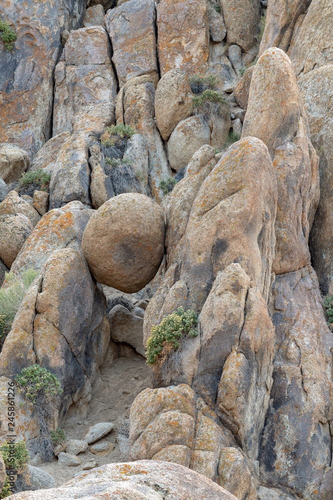A round boulder suspended between rocks in the Alabama Hills near Lone Pine, California, USA A round boulder suspended between rocks in the Alabama Hills near Lone Pine, California, USA