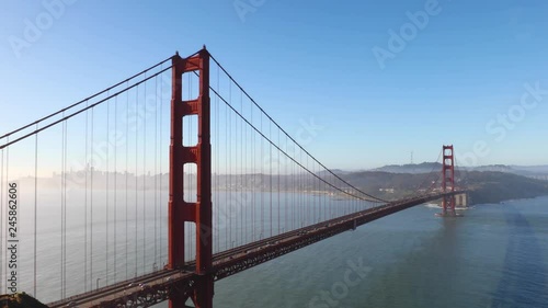 Traffic crosses the icon Golden Gate Bridge in early morning light. Looping.