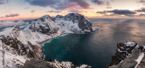 Panorama of Snowy mountain range with coastline at sunset