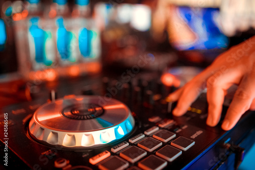 Dj mixes the track in the nightclub at party.