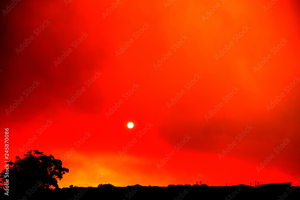 Obraz premium Sunset while fire burns smoke-filled sky