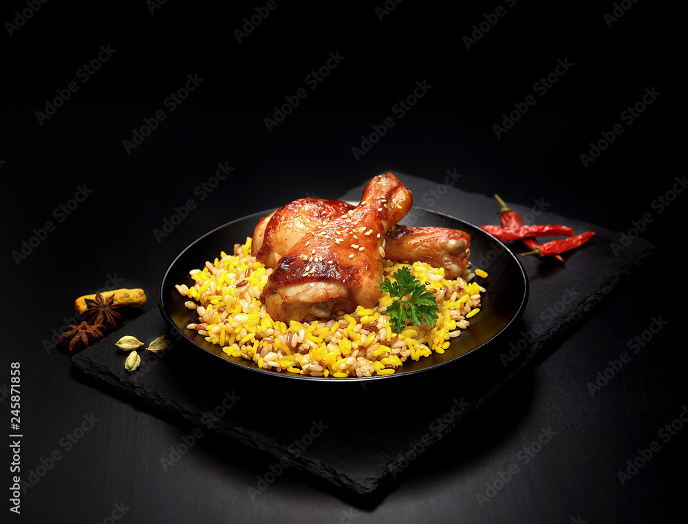 grilled chicken legs with sesame and rice on a black background. grilled chicken legs with sesame and rice on a black background.