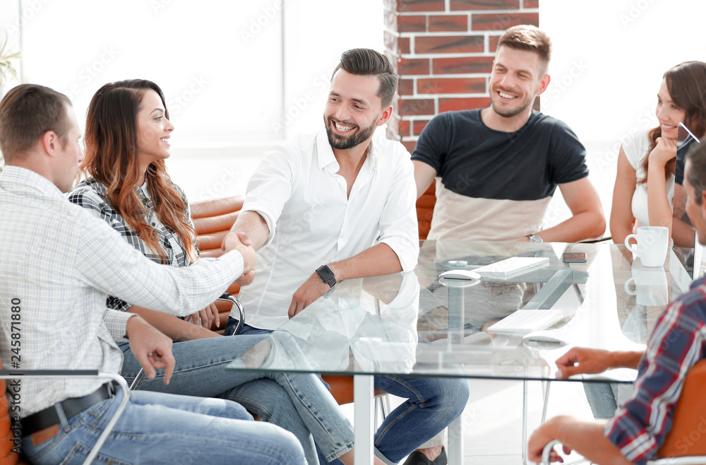 handshake of business partners sitting at the table