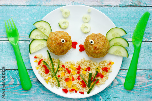 Food art idea healthy lunch for kids chicken meatballs with bulgur porridge and fresh vegetables shaped cute fishes