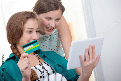 young woman and a teen girl buying on internet